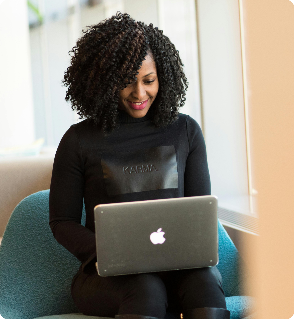 A woman in black clothes working on a mac computer.